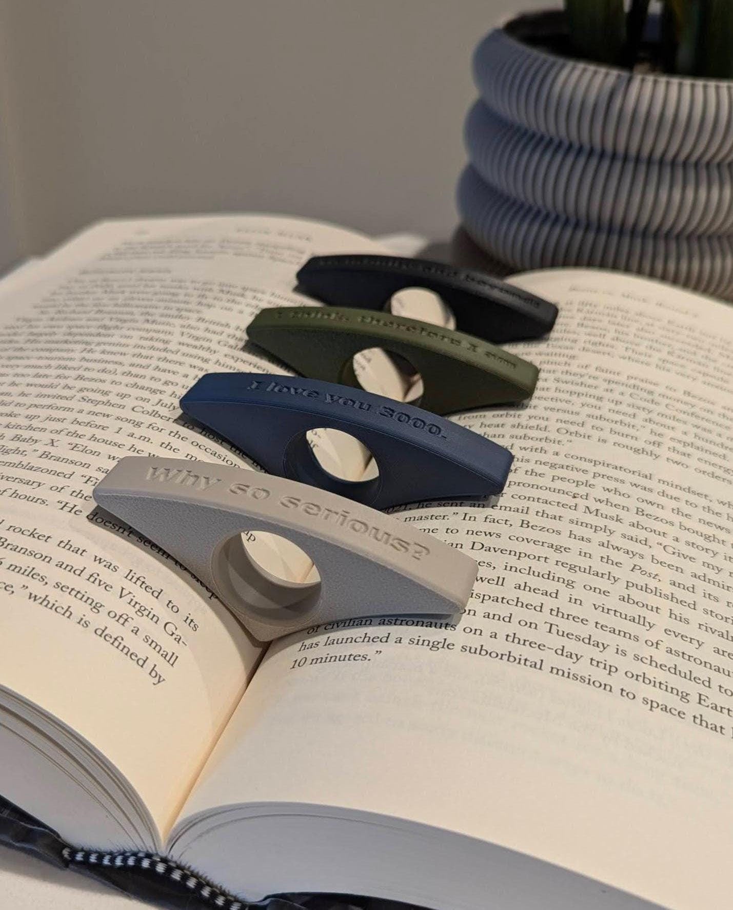 Showcasing colorful page holders with various text designs, gradually zooming out to reveal a display in multiple colors. In the background, an elegant ivory white Astria planter adds a minimalist touch to the scene.