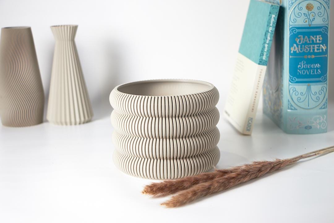 A single Aspen Ribbed Indoor Planter by EarthConcepts in Muted Ivory White. This modern minimalist planter has a 5-inch diameter, perfect for adding style to home decor.